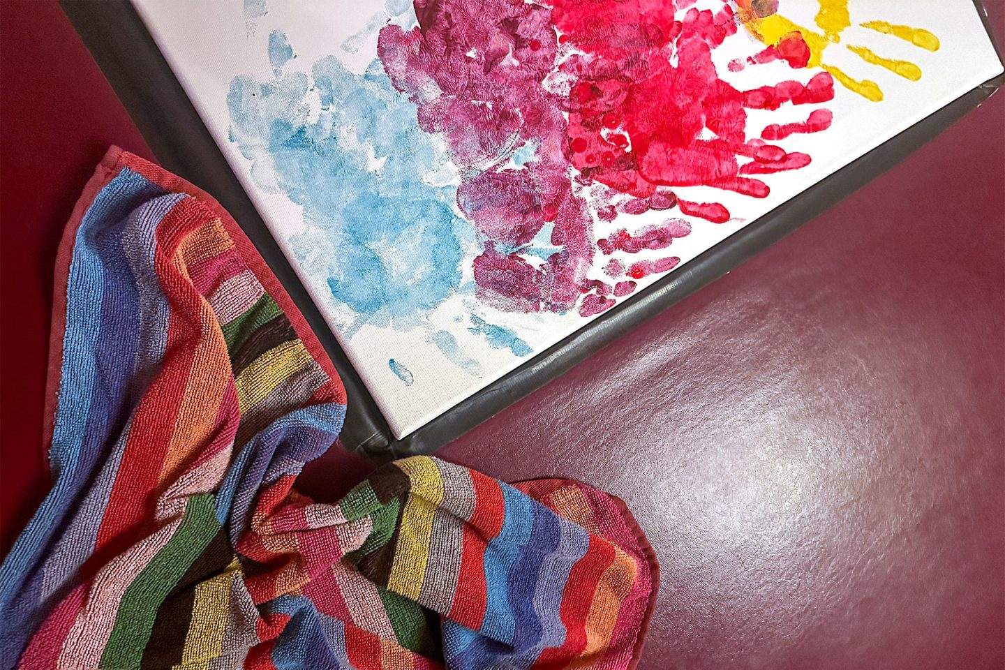 A creative painting featuring colorful handprints, made during a couples’ adventure in Ohio as part of a themed romantic retreat.