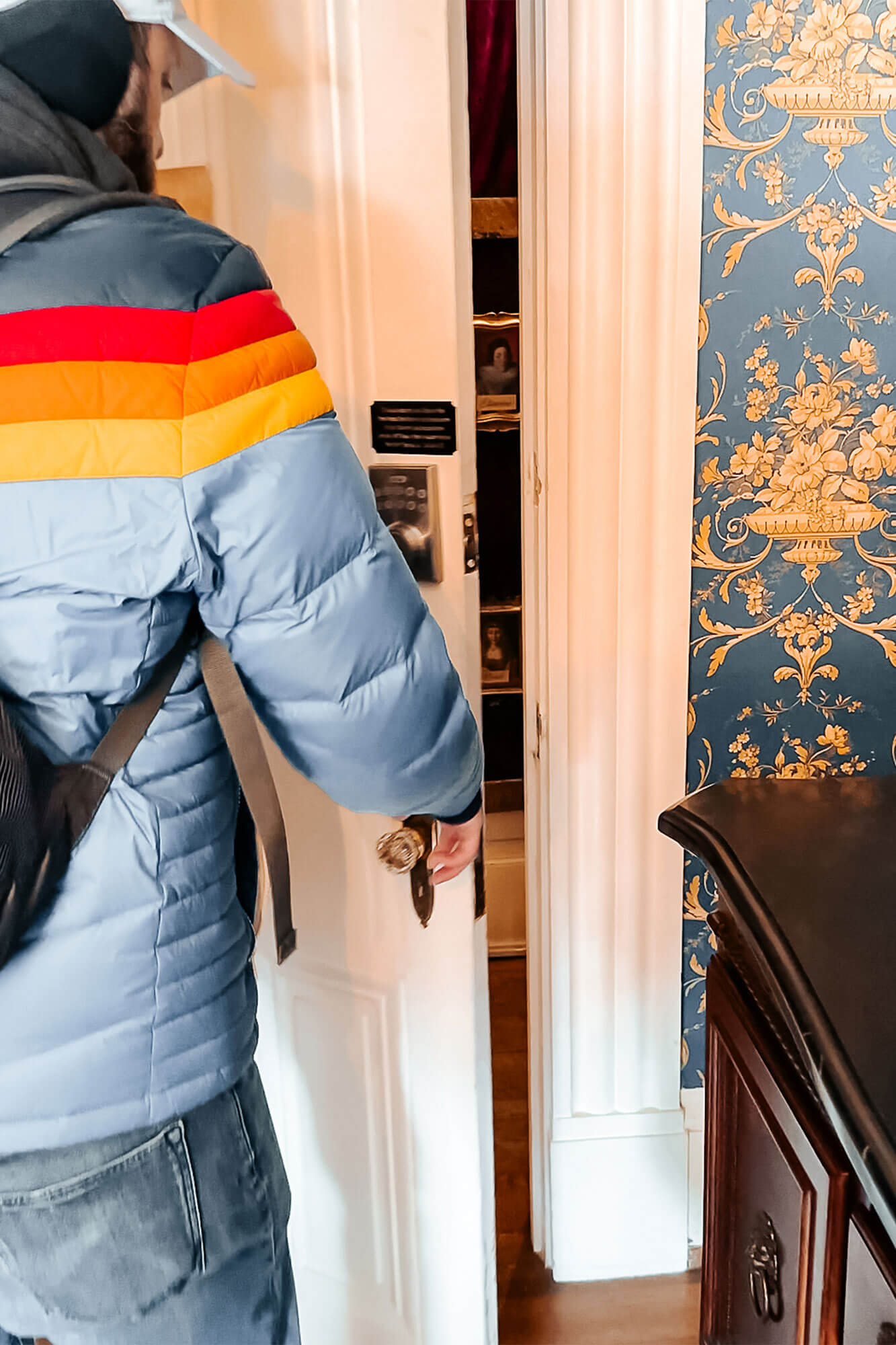A man opening the interior door to the King Louis XIV suite, a luxurious and adventurous hideaway in Ohio for couples looking for romance and fun surprises.