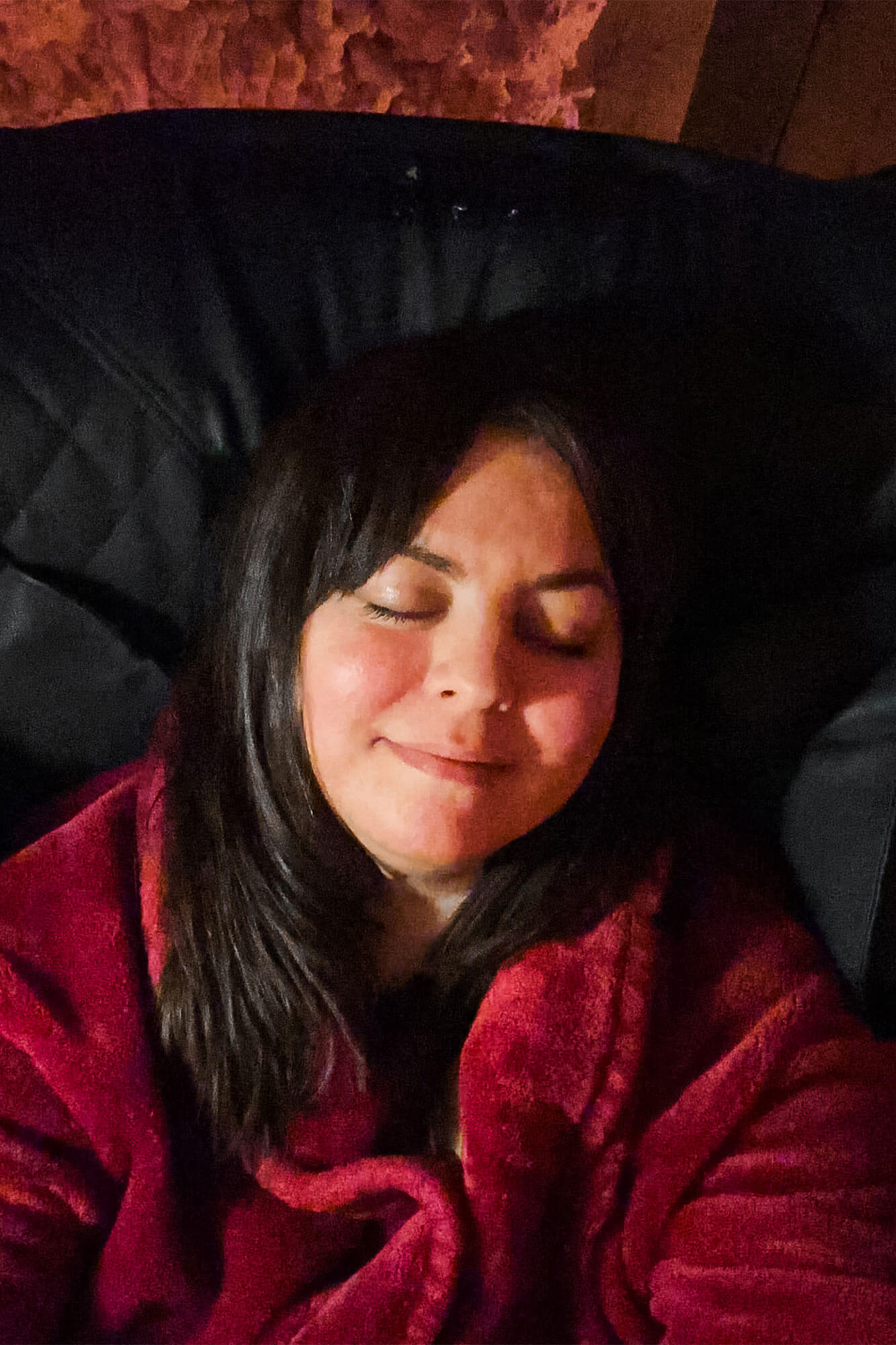 A woman reclining in a massage chair with eyes closed, enjoying the tranquil atmosphere of a romantic escape in Ohio.