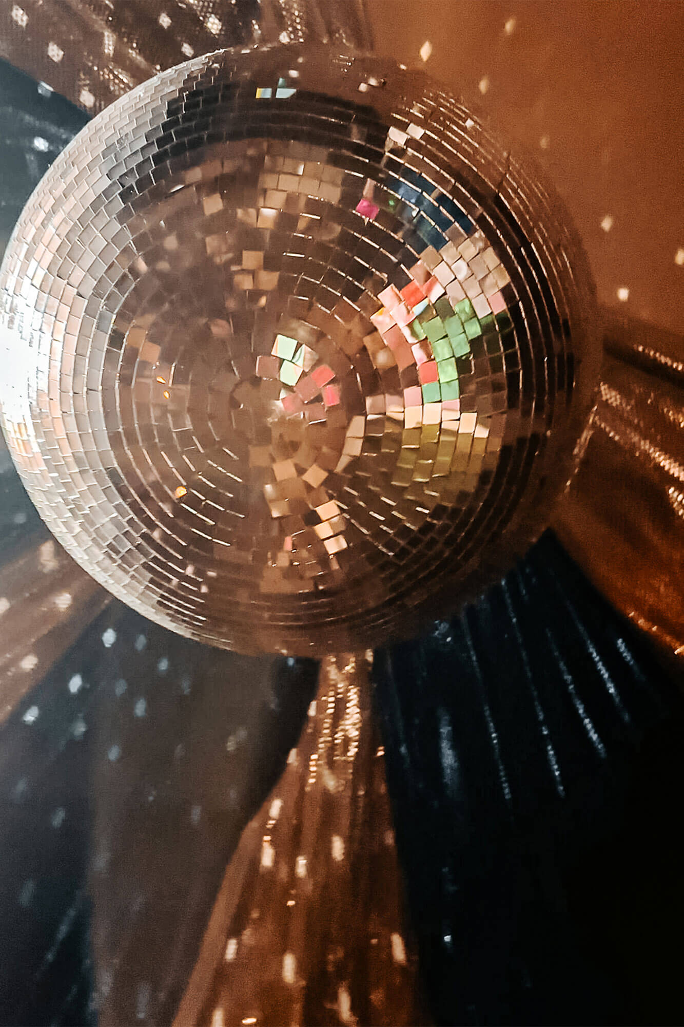 A shimmering disco ball casting colorful reflections of light across the room, adding a fun and romantic touch to the unique Ohio romantic getaway suite.